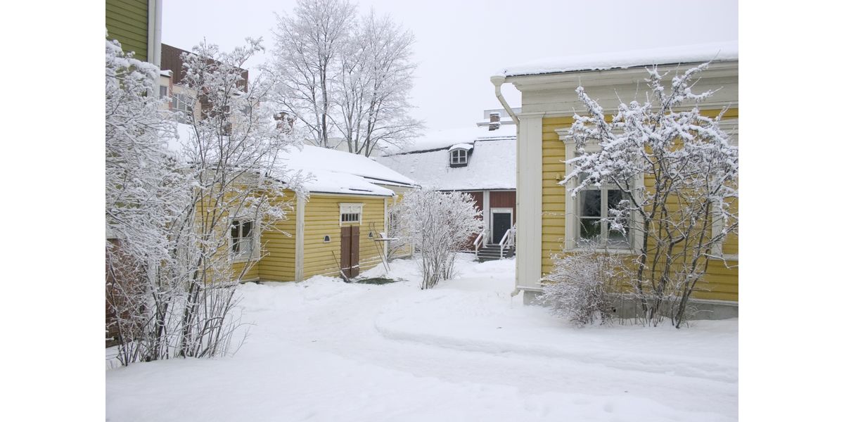 Kuva talvisesta ja lumisesta korttelimuseon pihasta. Kuvassa apteekki, suutarintupa, sekä 1930-luvun koti.
