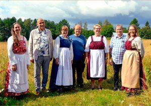 Triijuulla kansanmusiikkiyhtyeen jäsenet viljapellon laidalla kansallispuvut päällään