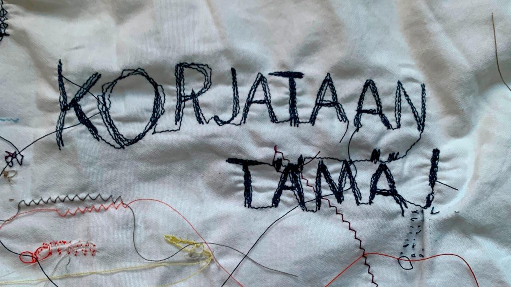 Kankaalle kirjottu teksti Korjataan tämä