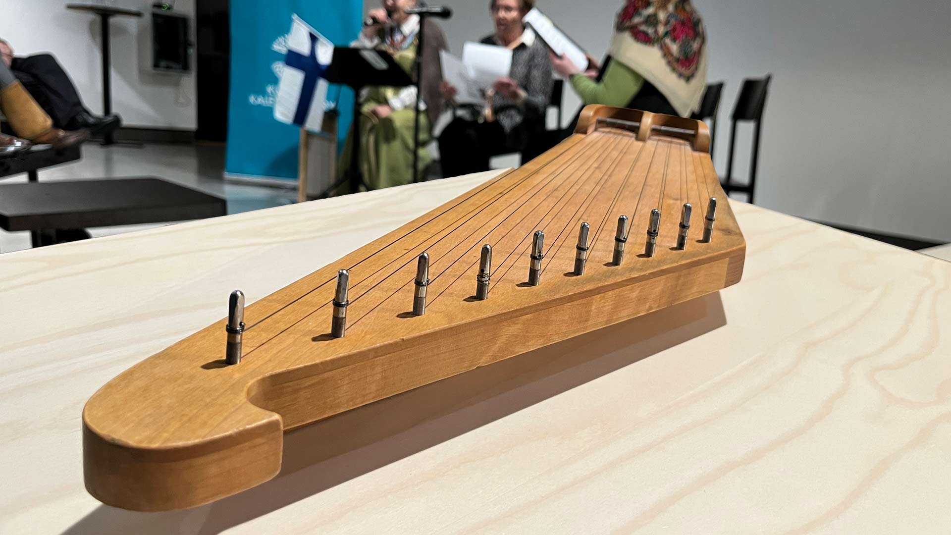 etualalla kantele, takana kansallispukuisia naisia