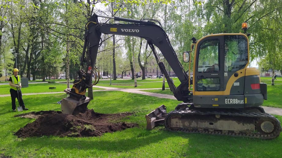 kaivinkone ja työmiehiä vanhalla hautapaikalla Piispanpuistossa Kuopiossa, kuvaaja Ville Laakso
