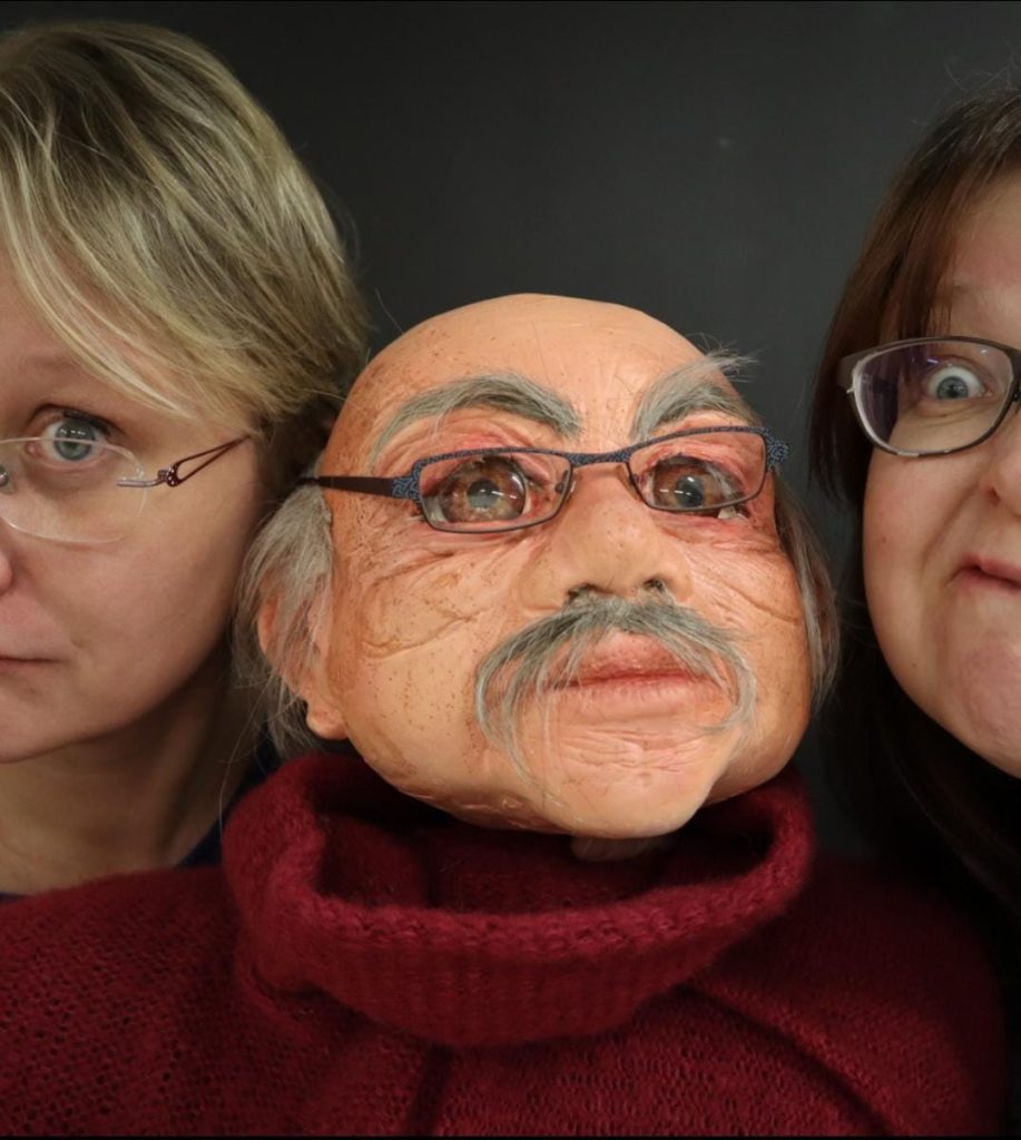 iso pappa-nukke ja kaksi nukettajaa