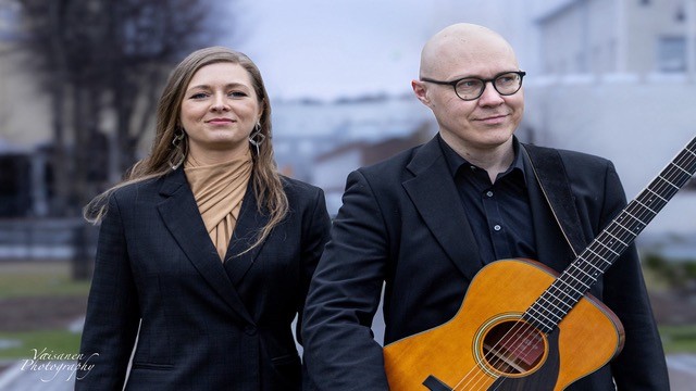 nainen sekä mies kitaran kanssa